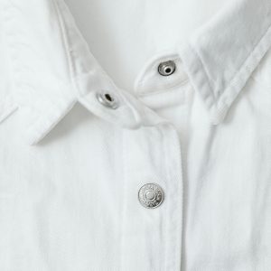 Detailed view of a white shirt's buttoned collar showcasing fabric texture.